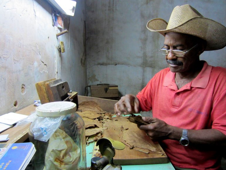 Cycling Cuba: man rolling a cigar