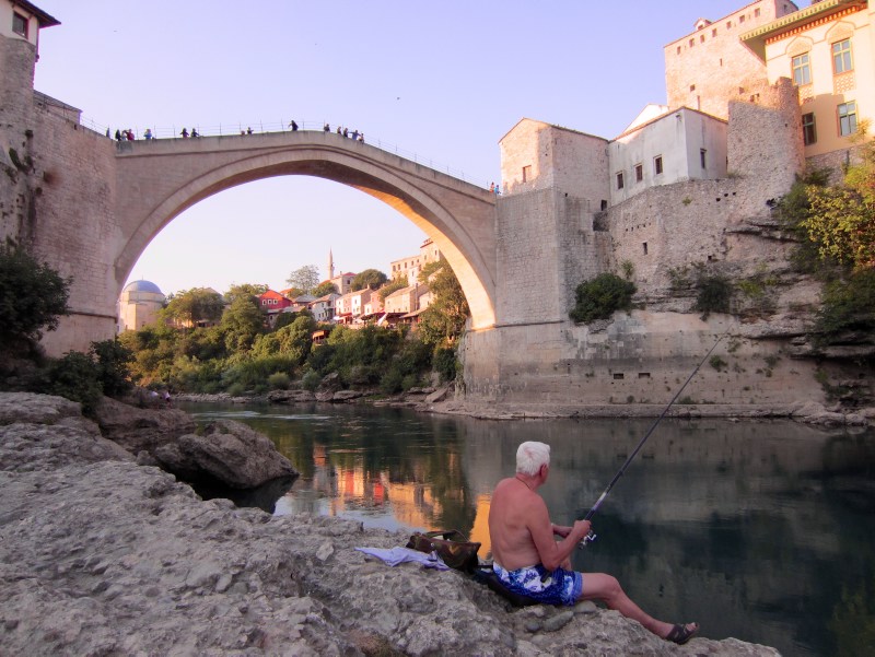 Man in front of Stari Most bridge in Mostar