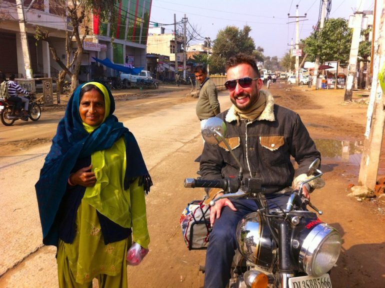 Renting an Enfield in India: Marco Buch on a Royal Enfield next to an Indian woman