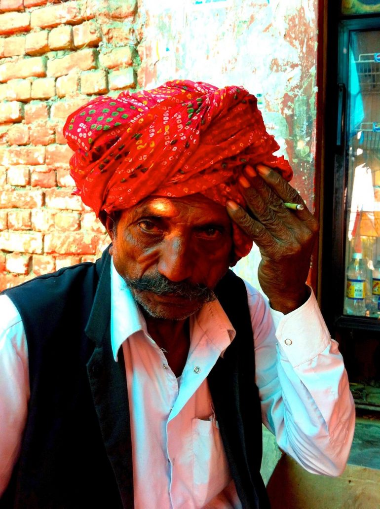 Alter Mann mit Zigarette und Turban am Strassenrand in Rajasthan