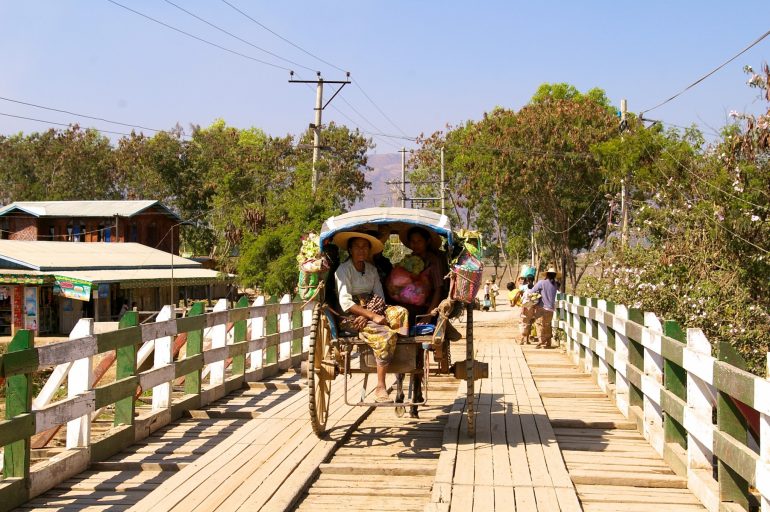 Kutsche mit Menschen auf einer Brücke in Myanmar