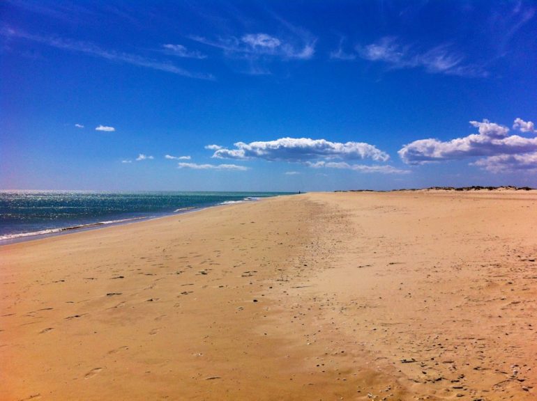 Agarve insider tips: Wide beach with clouds and ocean in Barril Beach