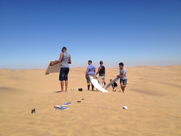 Menschen beim sandboarden in der Namib Wüste