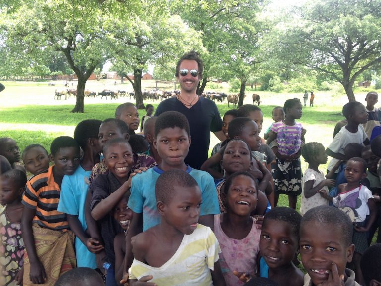 "Marco Buch" inmitten einer Gruppe Kinder in Malawi