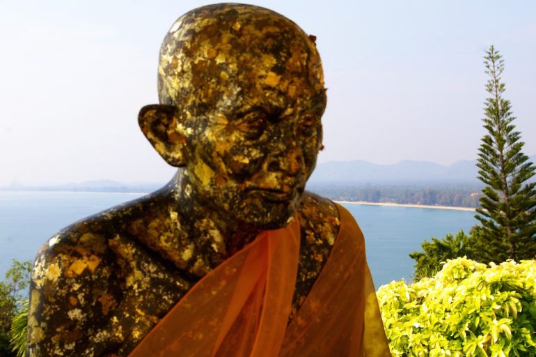 Thailand Highlights: Vergoldete Mönchsstatue vor einem Strand