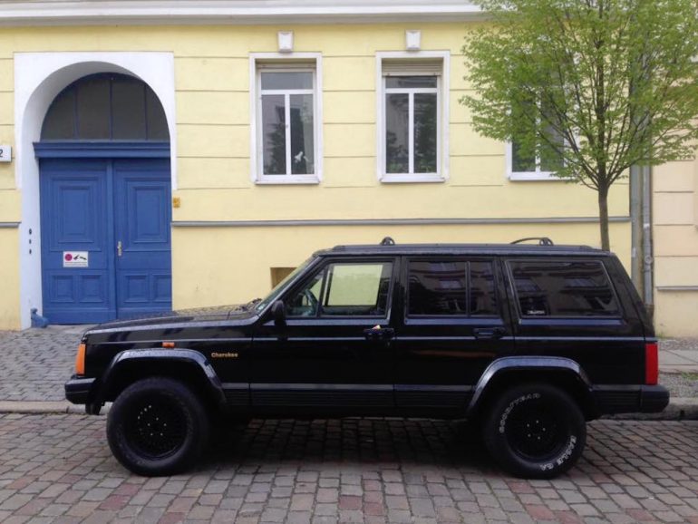 Oldtimer Berlin: Jeep Cherokee vor Hauswand