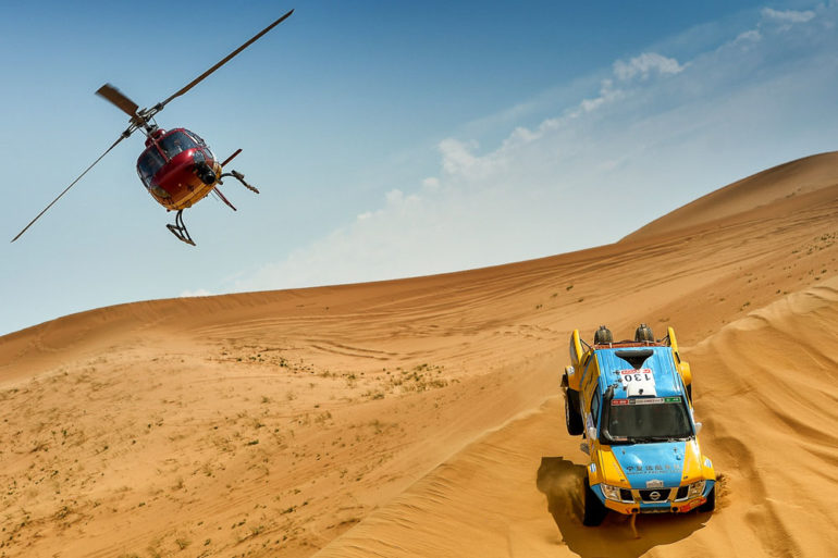 Dakar Rally in China: Helikopter und Geländewagen im Sand der Wüste Gobi