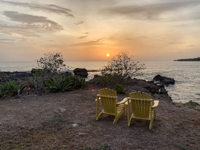 Jamaika Urlaub: Liegestühle vor Pflanzen und Meerl