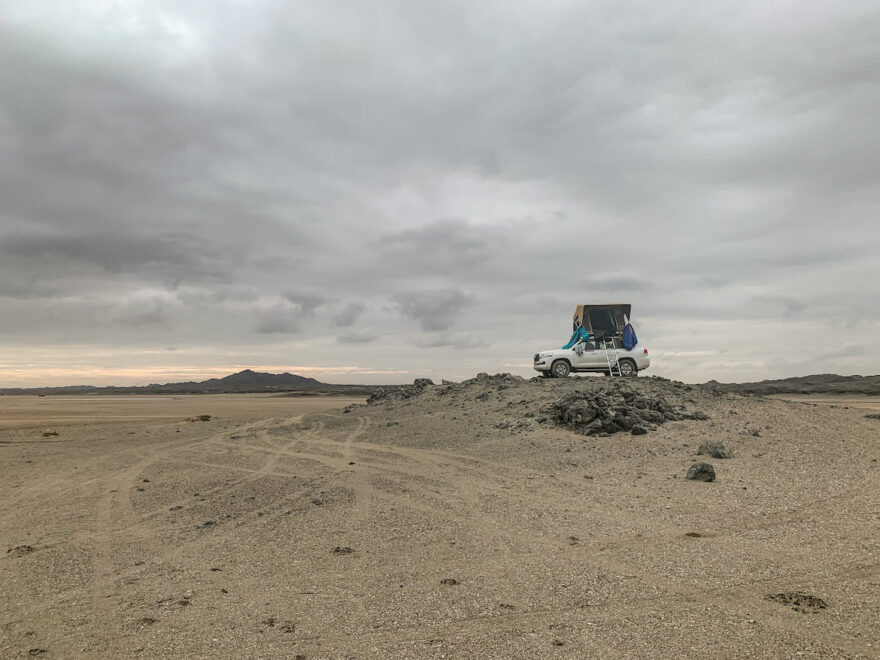 Geländewagen auf einem Felsen am Strand im Oman