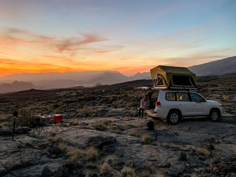 Geländewagen auf felsen vor Sonnenuntergang im Oman