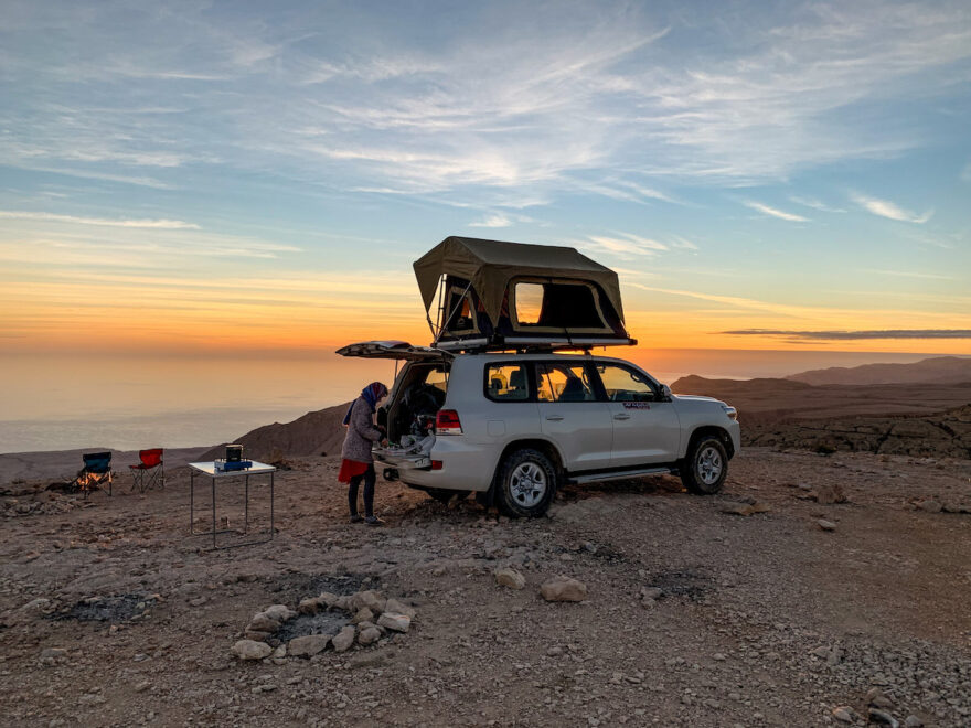 Frau neben Geländewagen auf einem Oman Roadtrip