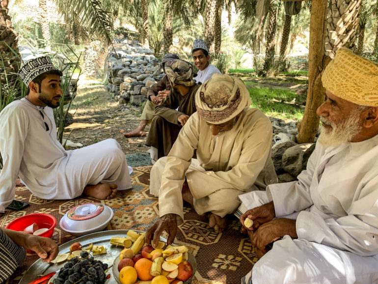 Omanische Männer trinken Kaffee in einer Oase