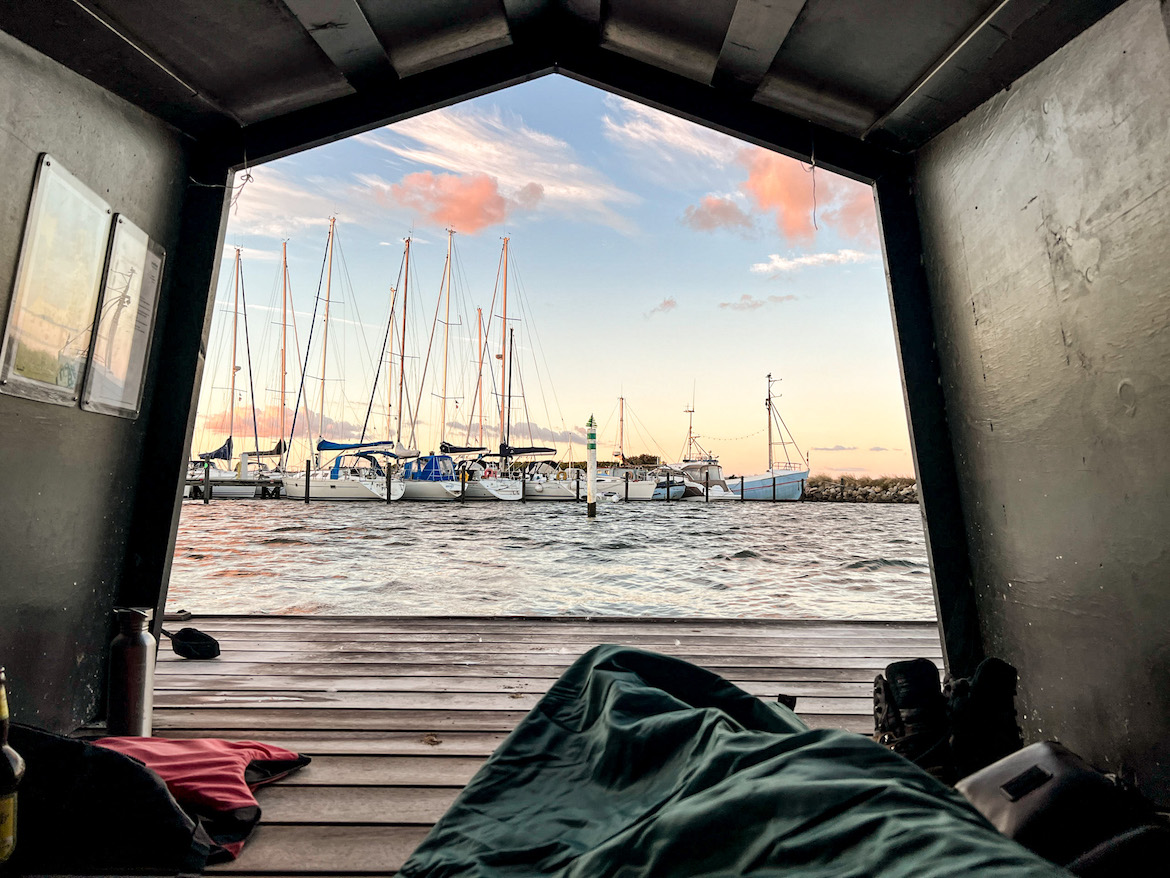 Blick aus einer Hütte auf Segelboote im Hafen